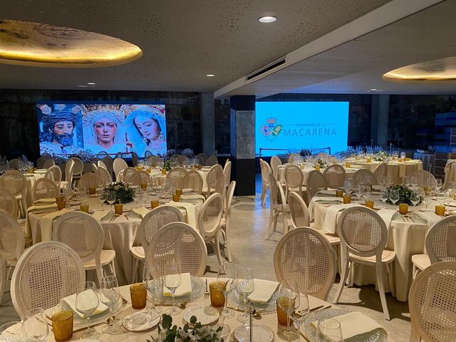 Salón montado para un evento de empresa en Sevilla, con mesas redondas y pantallas de proyección