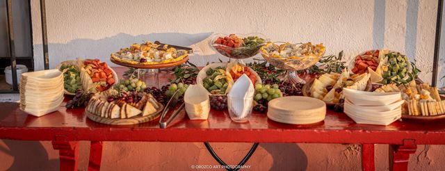 Mesa larga de aperitivos con montaditos, ensaladas y picoteo para un cóctel en Sevilla