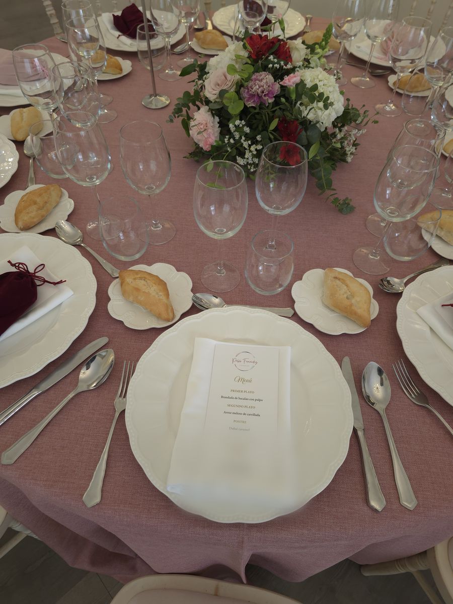 Plato de presentación con la minuta del menú sobre mesa vestida en rosa empolvado