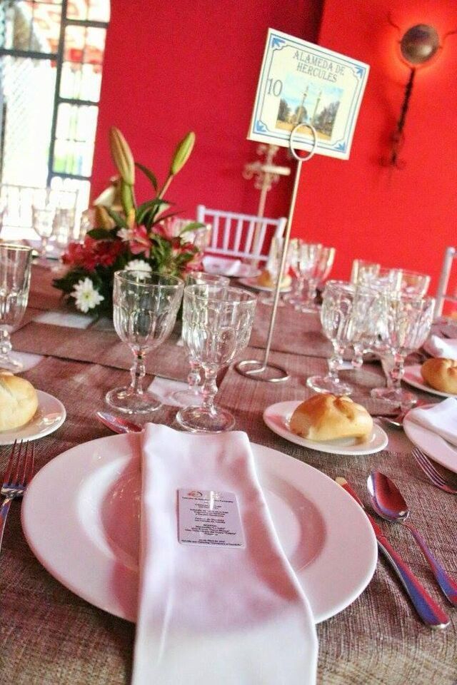 Mesa vestida y numerada preparada para una celebración en un salón de Sevilla