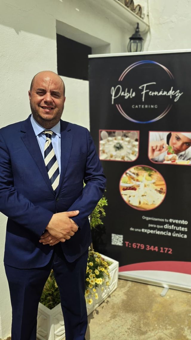 Pablo Fernández, fundador de Pablo Fernández Catering, junto al roll-up corporativo de la empresa