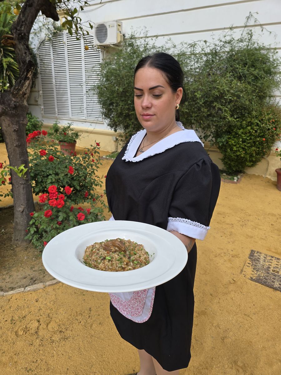 Integrante del equipo de sala llevando un plato durante el servicio